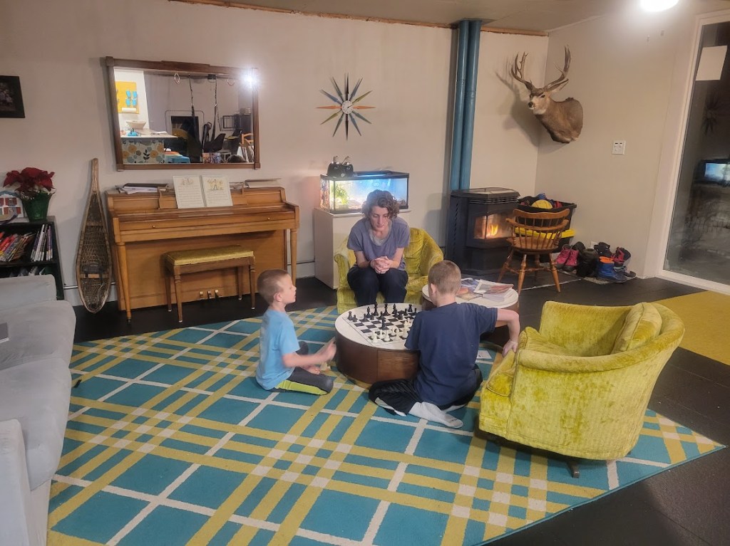 Heather plays chess with her son
